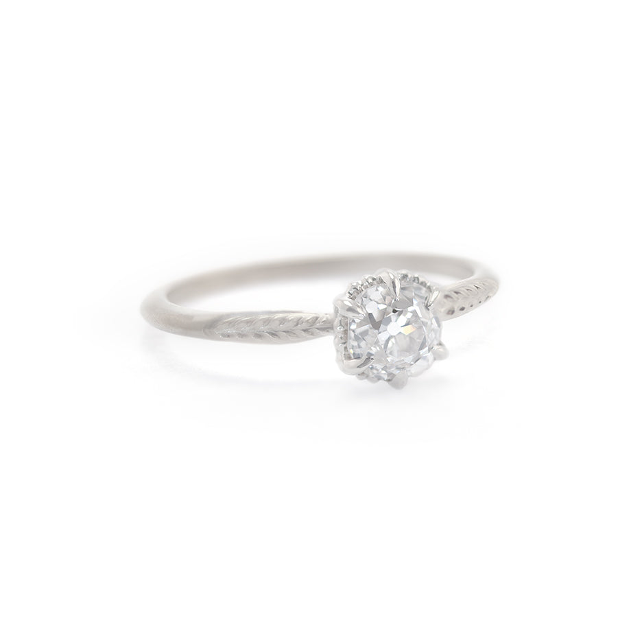 Handmade classic engagement ring featuring antique old mine cut diamond with botanical Evergreen details in 18K white gold by Designer Megan Thorne