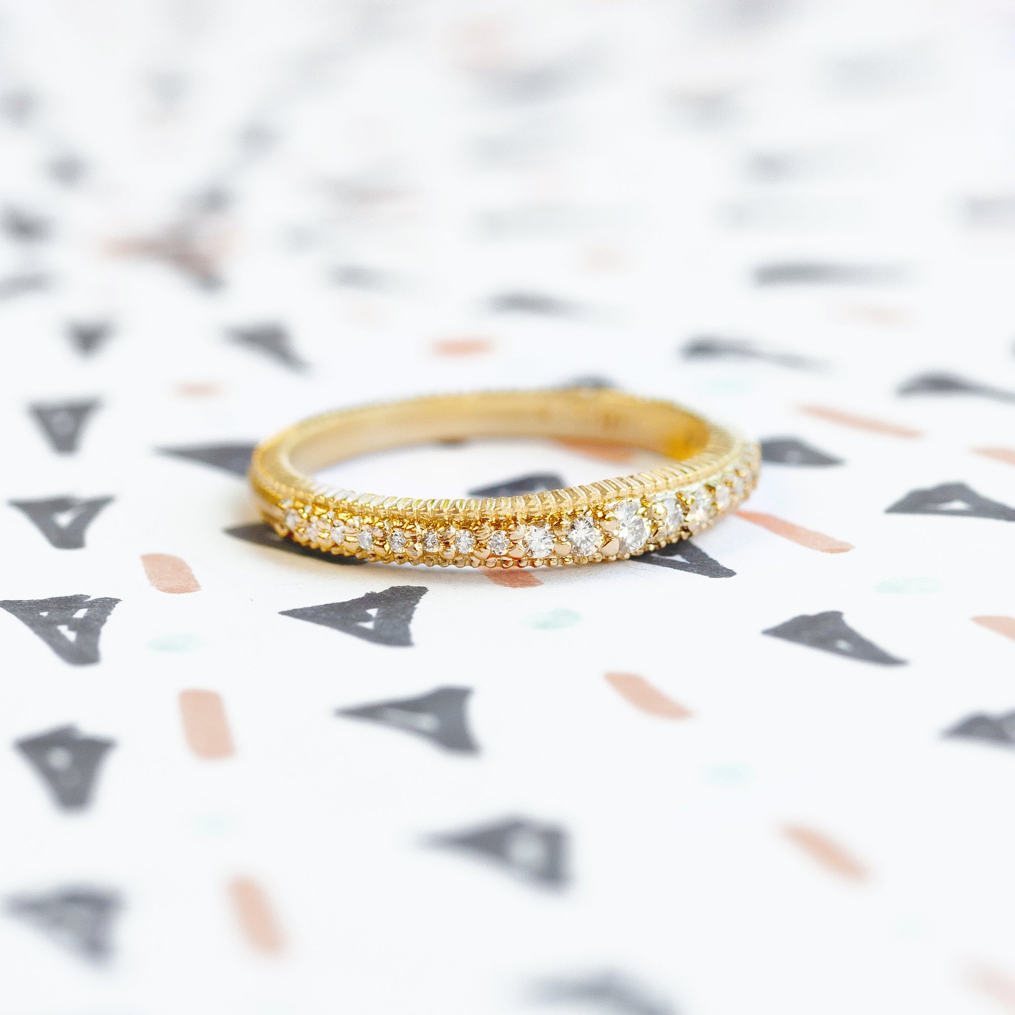 Handmade classic wedding band with graduated size diamonds and ribbing in 18K yellow gold by Designer Megan Thorne 