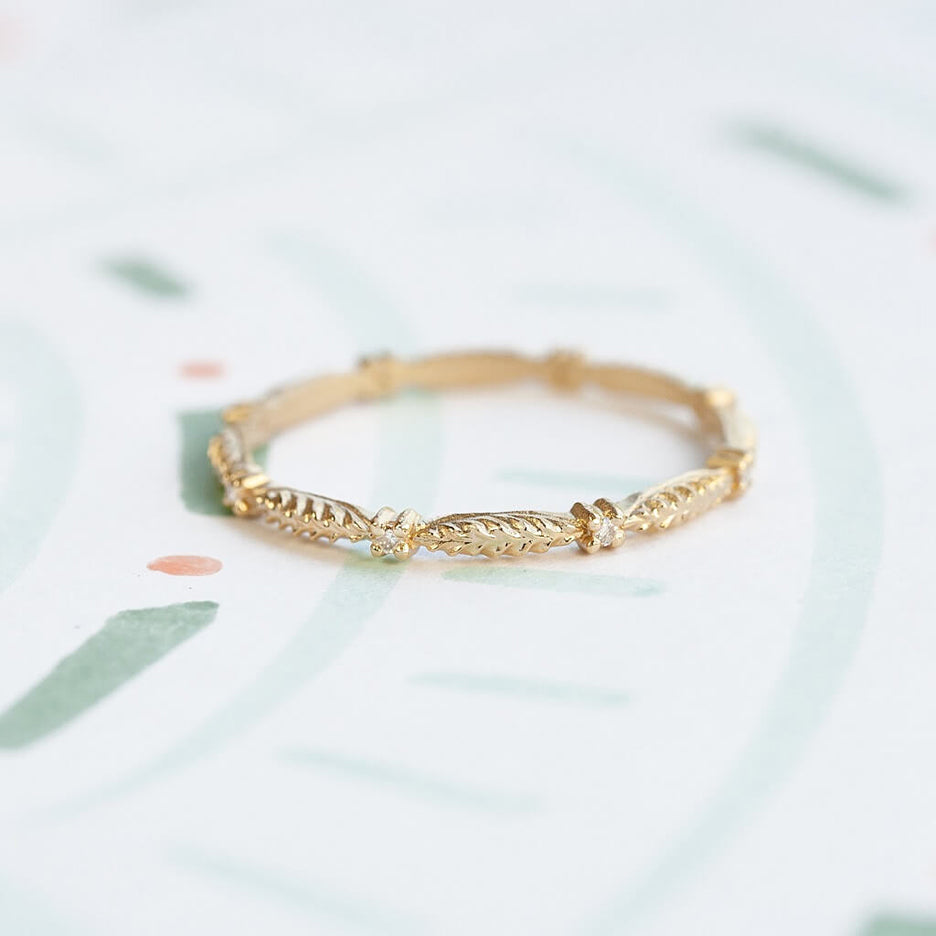 Handmade wedding or stacking band with botanical Evergreen details and diamonds in 18K yellow gold by Designer Megan Thorne