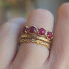 Handmade ribbed topper statement wedding band with rose cut rubies and diamonds in 18K yellow gold by Designer Megan Thorne pictured on hand with stacking bands