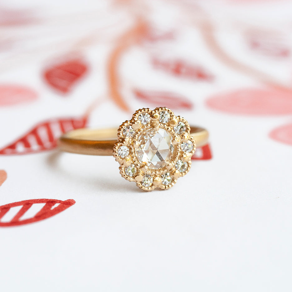 Handmade vintage inspired engagement ring with lacy diamond mosaic halo and a rose cut center diamond in 18K yellow gold by Designer Megan Thorne