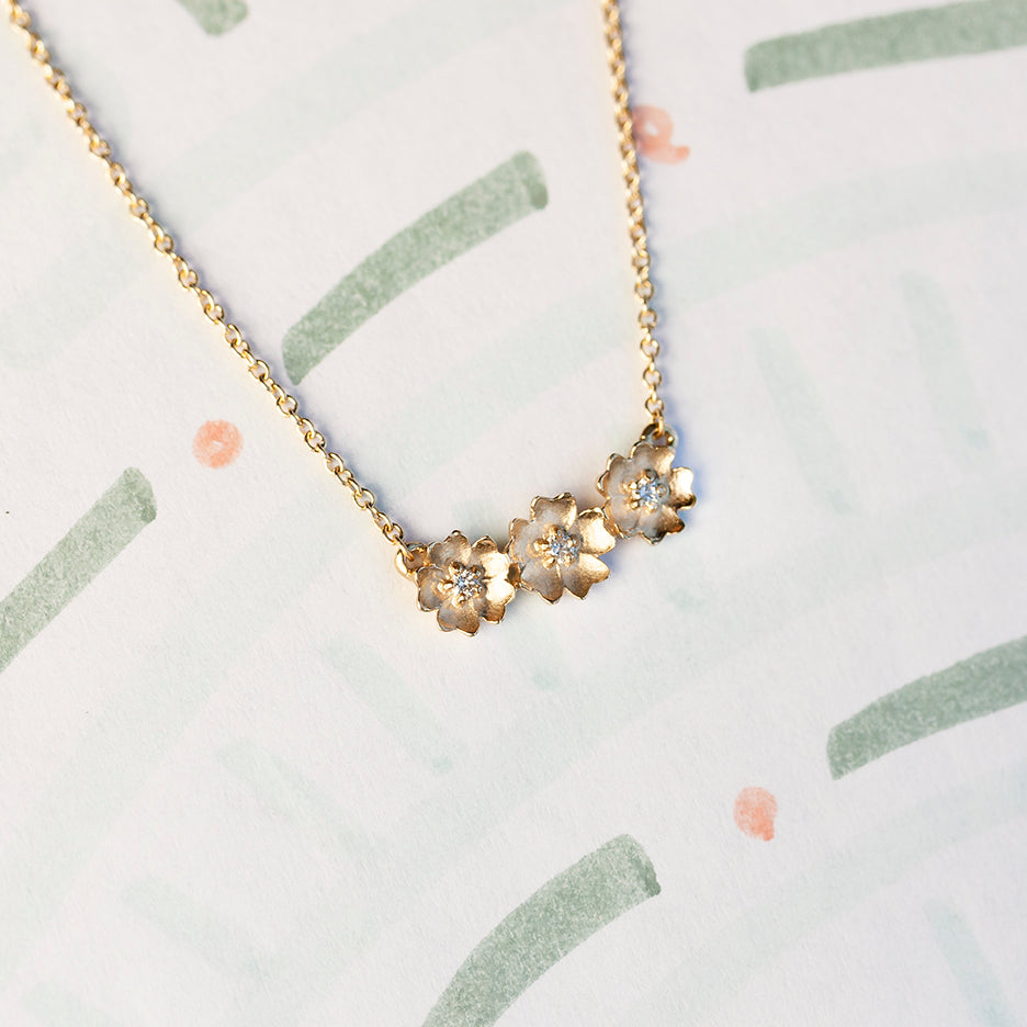 Handmade floral necklace with three Buttercup flowers with diamonds in 18K yellow gold by Designer Megan Thorne
