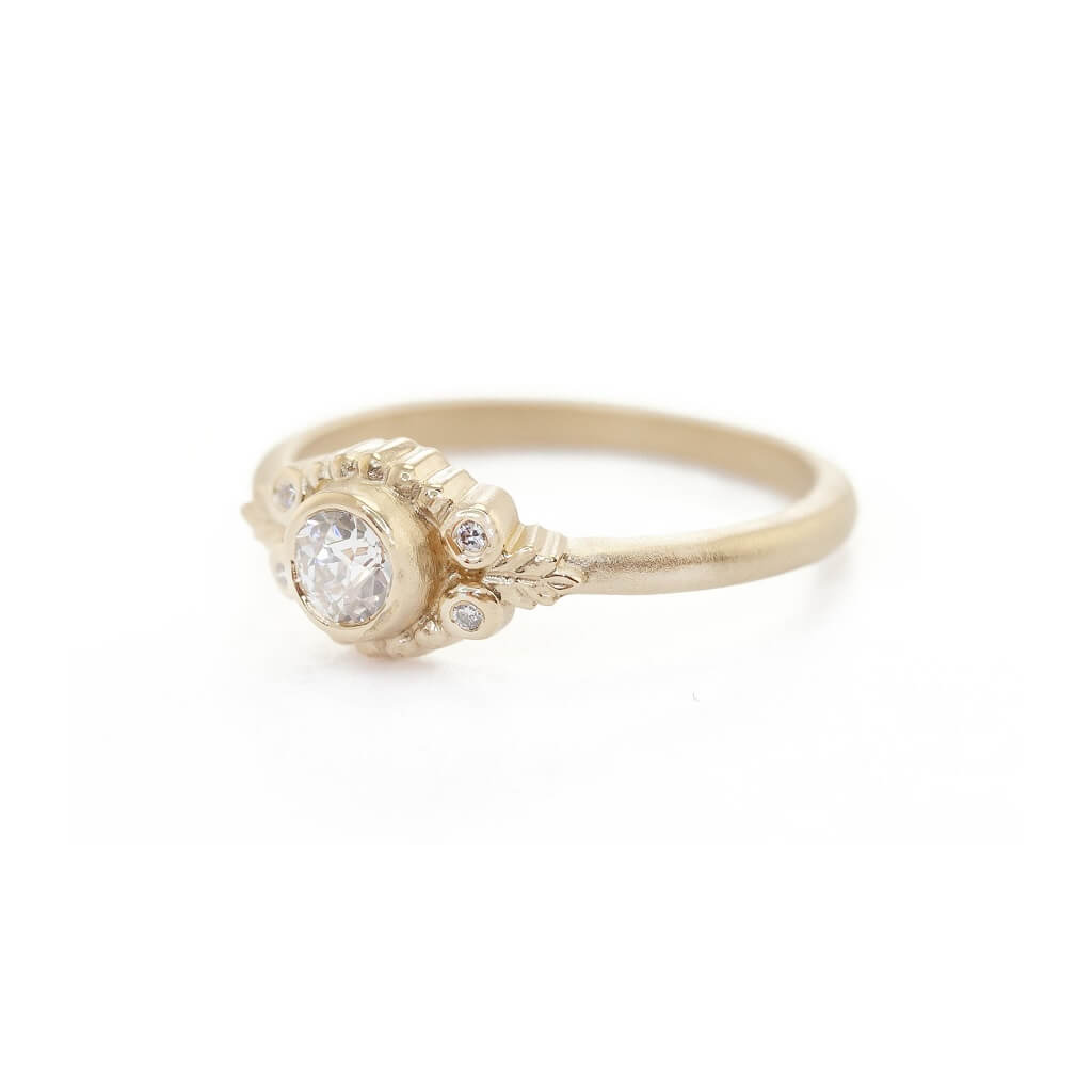 Handmade classic engagement ring featuring antique diamond and floral wood nymph details and bezel set diamonds in 18K yellow gold by Designer Megan Thorne