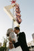 Newly married couple posing in front of Vegas sign wearing engagement and wedding ring by Designer Megan Thorne