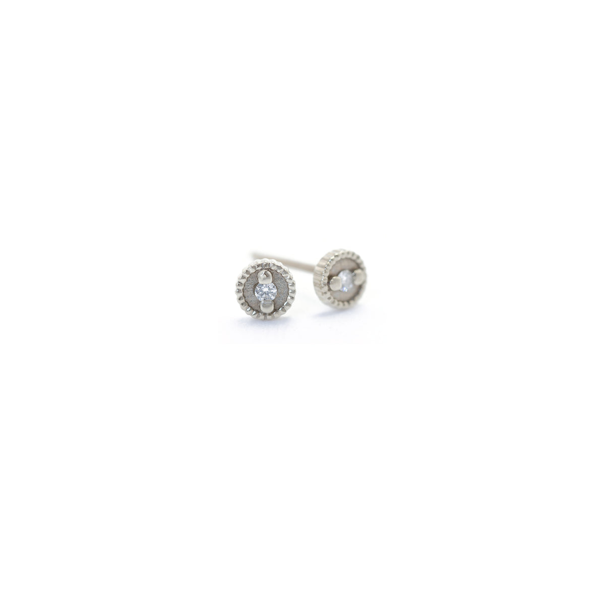 Handmade round studs with diamonds and hand carved ribbing in 18K white gold