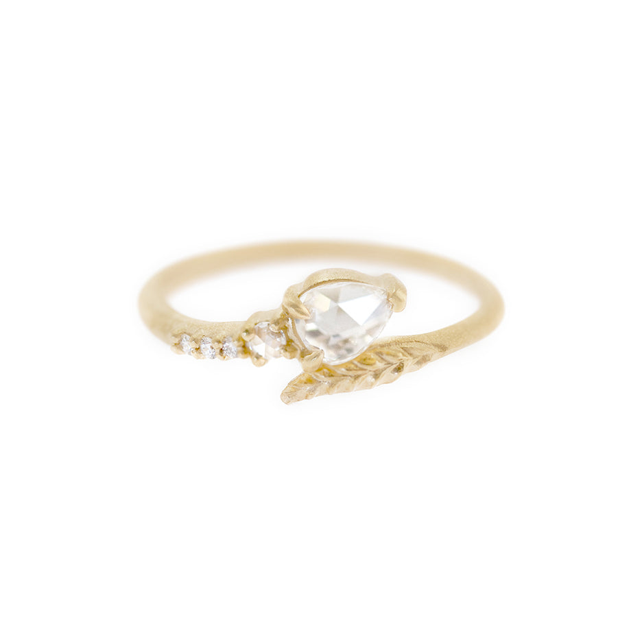 Handmade vintage inspired engagement ring with unexpected Evergreen leaf encircling a pear rose cut diamond and diamond accents in 18K yellow gold by Designer Megan Thorne