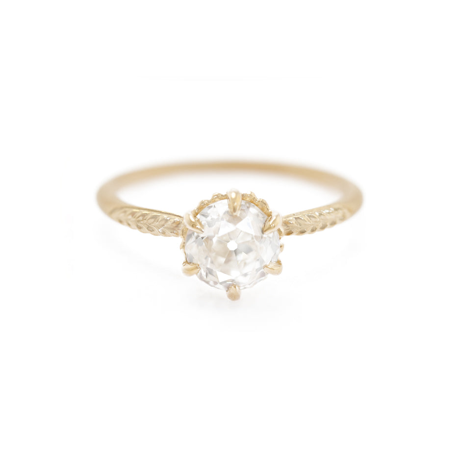 Handmade solitaire engagement ring with 1.23ct old mine cut diamond and botanical Evergreen elements in 18K yellow gold by Designer Megan Thorne
