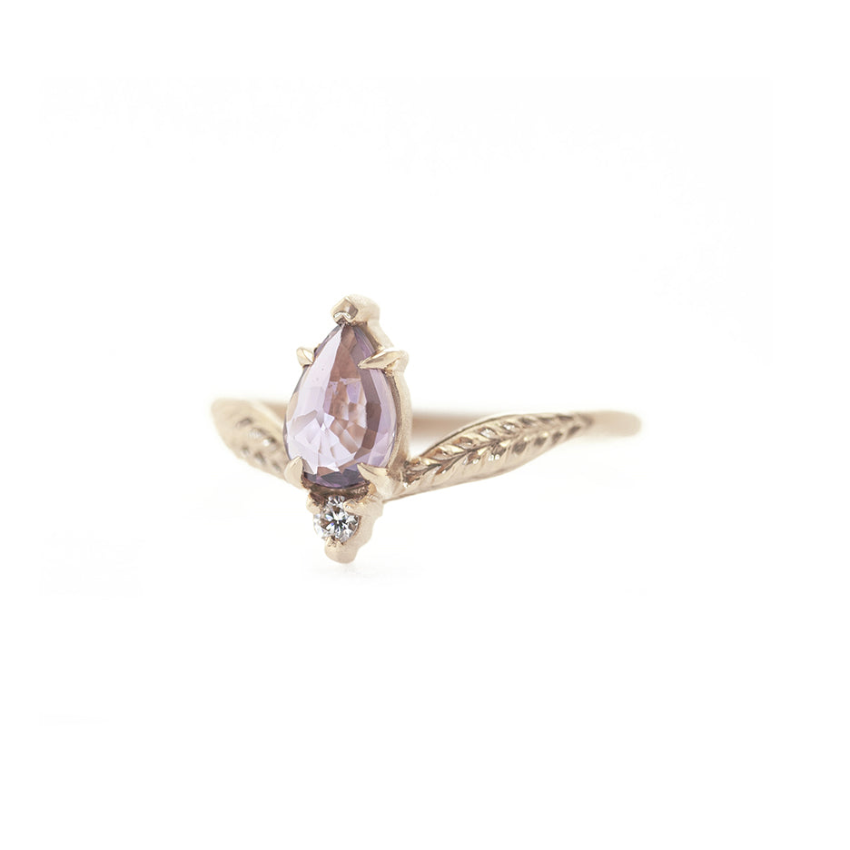 Handmade engagement ring with low set purple pear sapphire and diamond accent stone in 18K yellow gold by Designer Megan Thorne