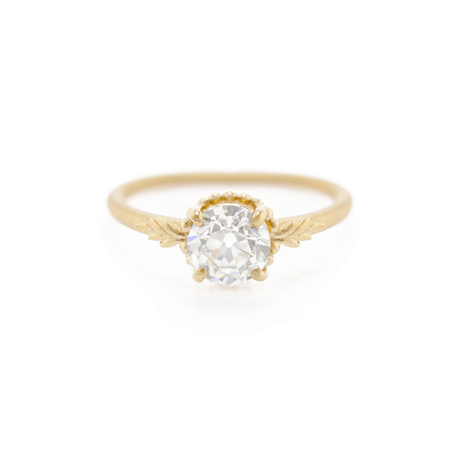 Handmade classic solitaire engagement ring featuring lab grown colorless old european cut diamond and floral elements in 18K yellow gold by Designer Megan Thorne