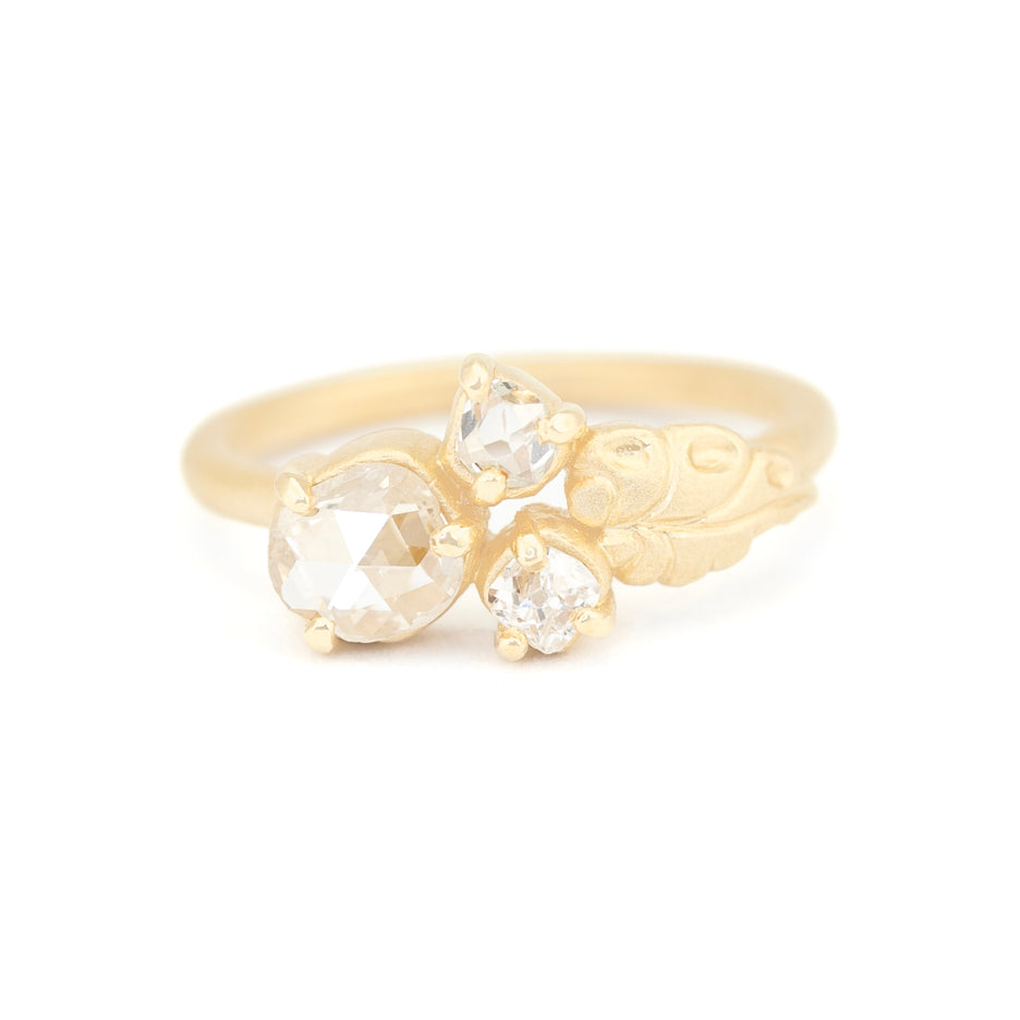 Handmade nontraditional engagement ring featuring 3 rustic antique diamonds and floral leaf details in 18K yellow gold by Designer Megan Thorne