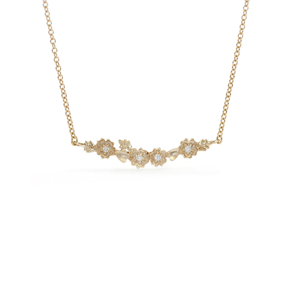 Handmade everyday bar necklace with floral Buttercup stations and botanical leaves in 18K yellow gold by Designer Megan Thorne