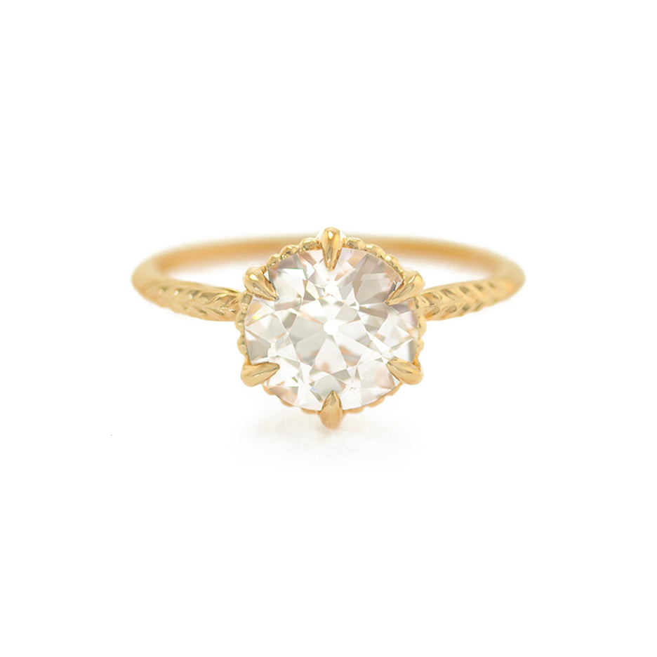 Handmade classic solitaire engagement ring featuring large warm fancy colored GIA 1.7ct light champagne Old European Cut Diamond and botanical Evergreen details in 18K yellow gold by Designer Megan Thorne