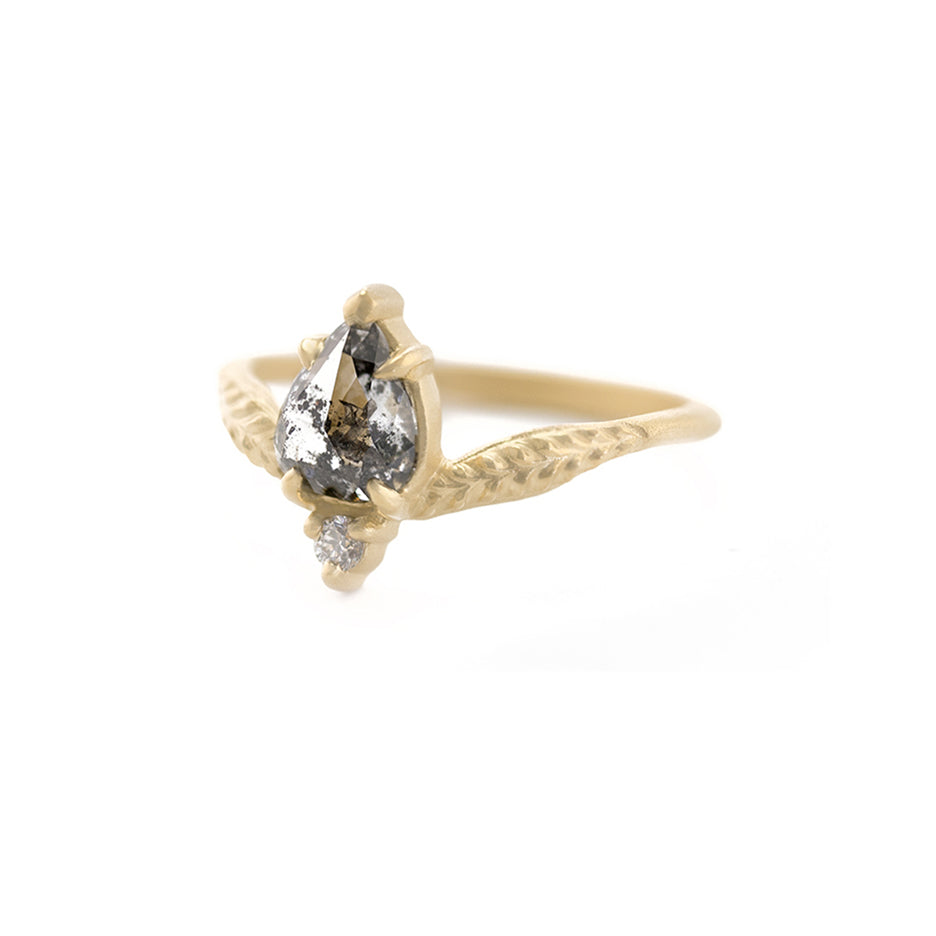 Handmade alternative engagement ring featuring salt and pepper diamond and antique diamond accent with botanical Evergreen details in 18K yellow gold by Designer Megan Thorne