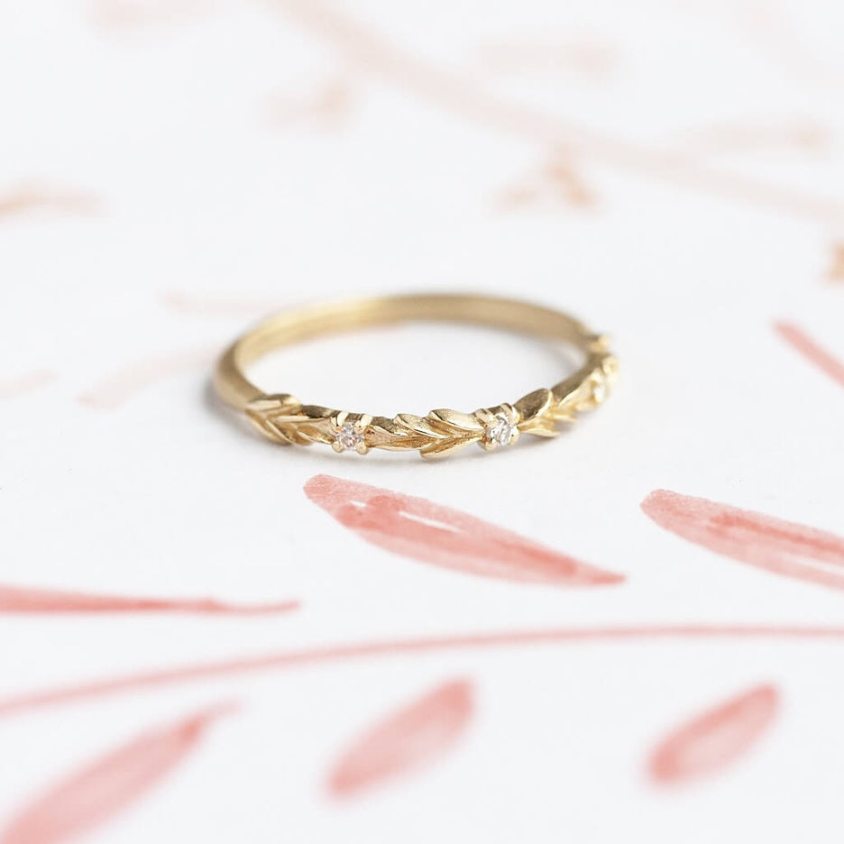 Handmade wedding band with floral details in the top third and diamond accent stones by Designer Megan Thorne