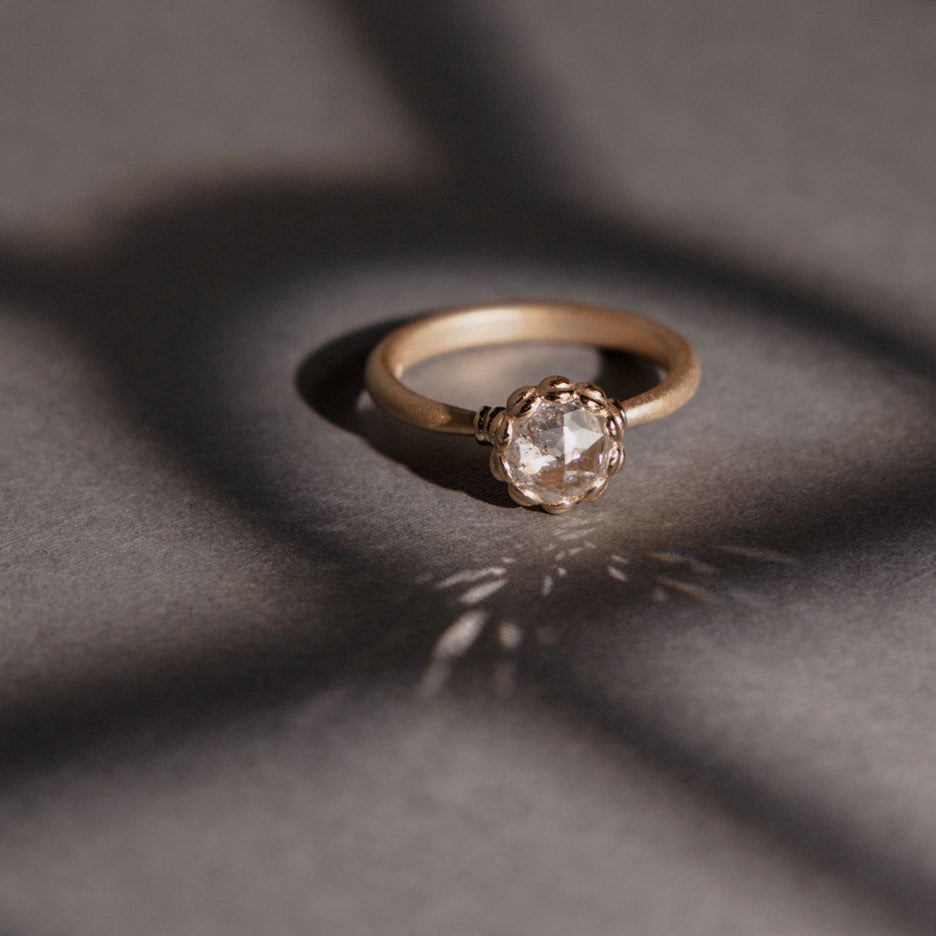 Rose Cut Diamond Ring in Yellow Gold with Detailing on Colored Background