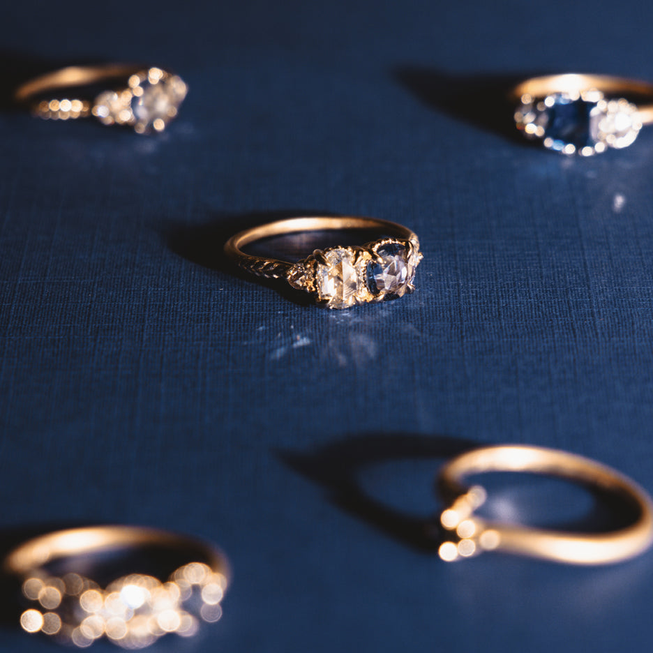 Diamond and Sapphire Engagement Ring in Yellow Gold with Detailing on Colored Background