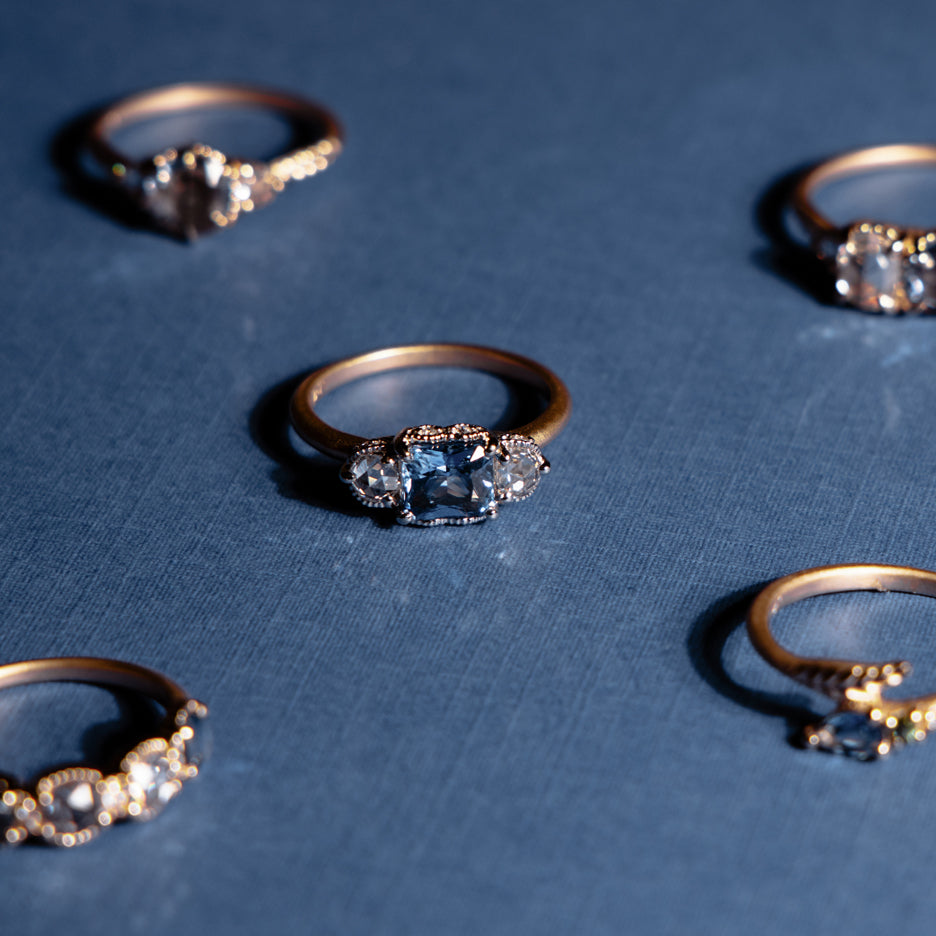 Blue Sapphire and Rose Cut Diamond Two Tone Ring with Detailing on Colored Background