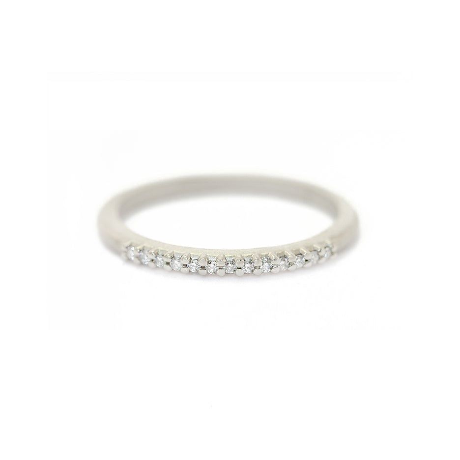 Handmade wedding band with pave diamond details covering the top 1/4 of the ring in 18K white gold by Designer Megan Thorne