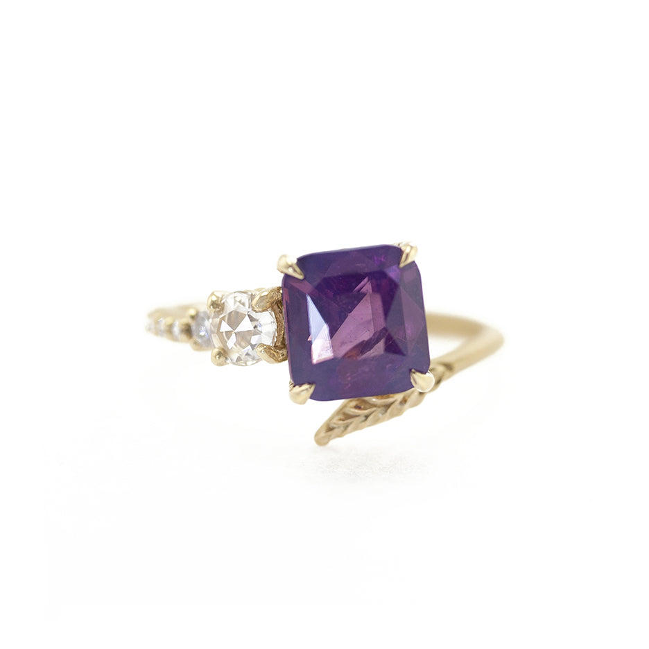 Handmade engagement ring with silky purple sapphire and diamond accent stones with asymmetrical setting in 18K yellow gold by Designer Megan Thorne