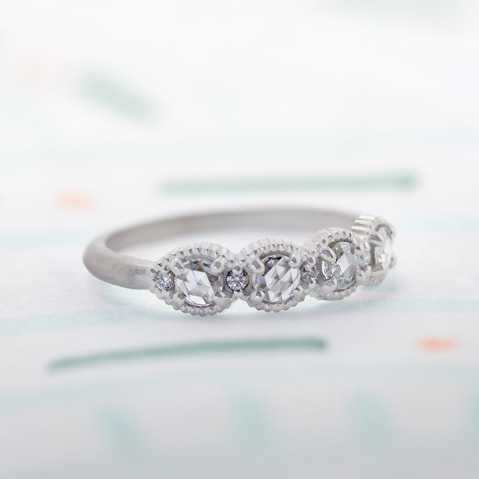 Handmade classic wedding band with rose cut diamonds and ribbed details in 18K white gold by Designer Megan Thorne on colored background