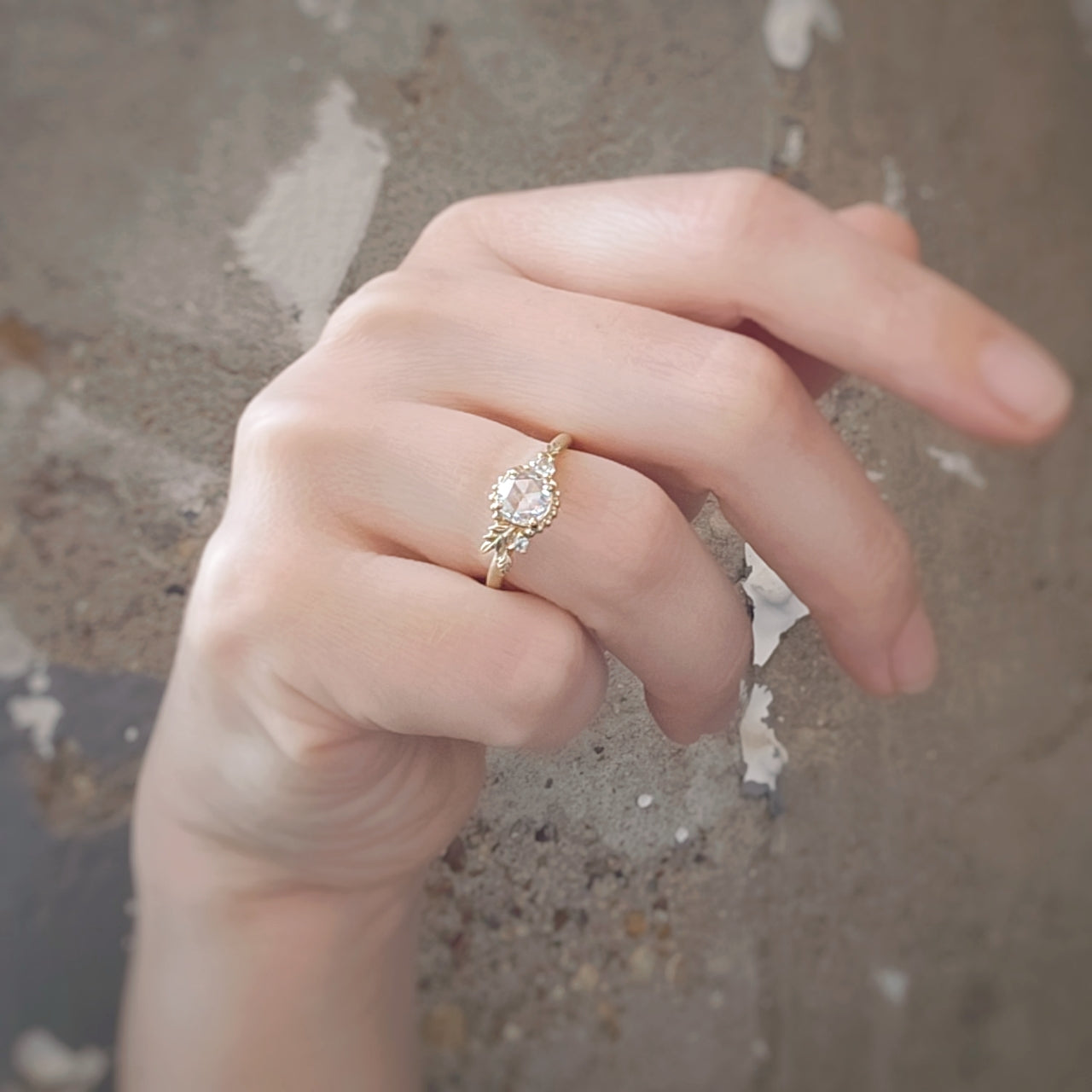 Handmade classic engagement ring featuring a rose cut diamond and diamond accents with floral Wood Nymph details in 18K yellow gold by Designer Megan Thorne