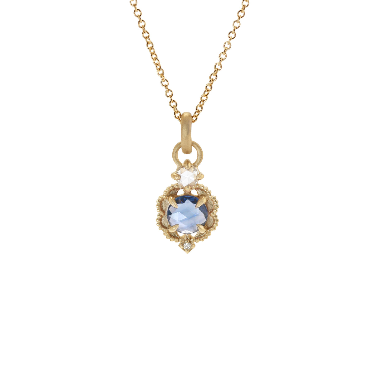 Handmade pendant necklace featuring vintage inspired venise frame setting and rose cut and round brilliant cut diamond accents and blue rose cut sapphire center stone with claw prongs and beading in 18K yellow gold by Designer Megan Thorne