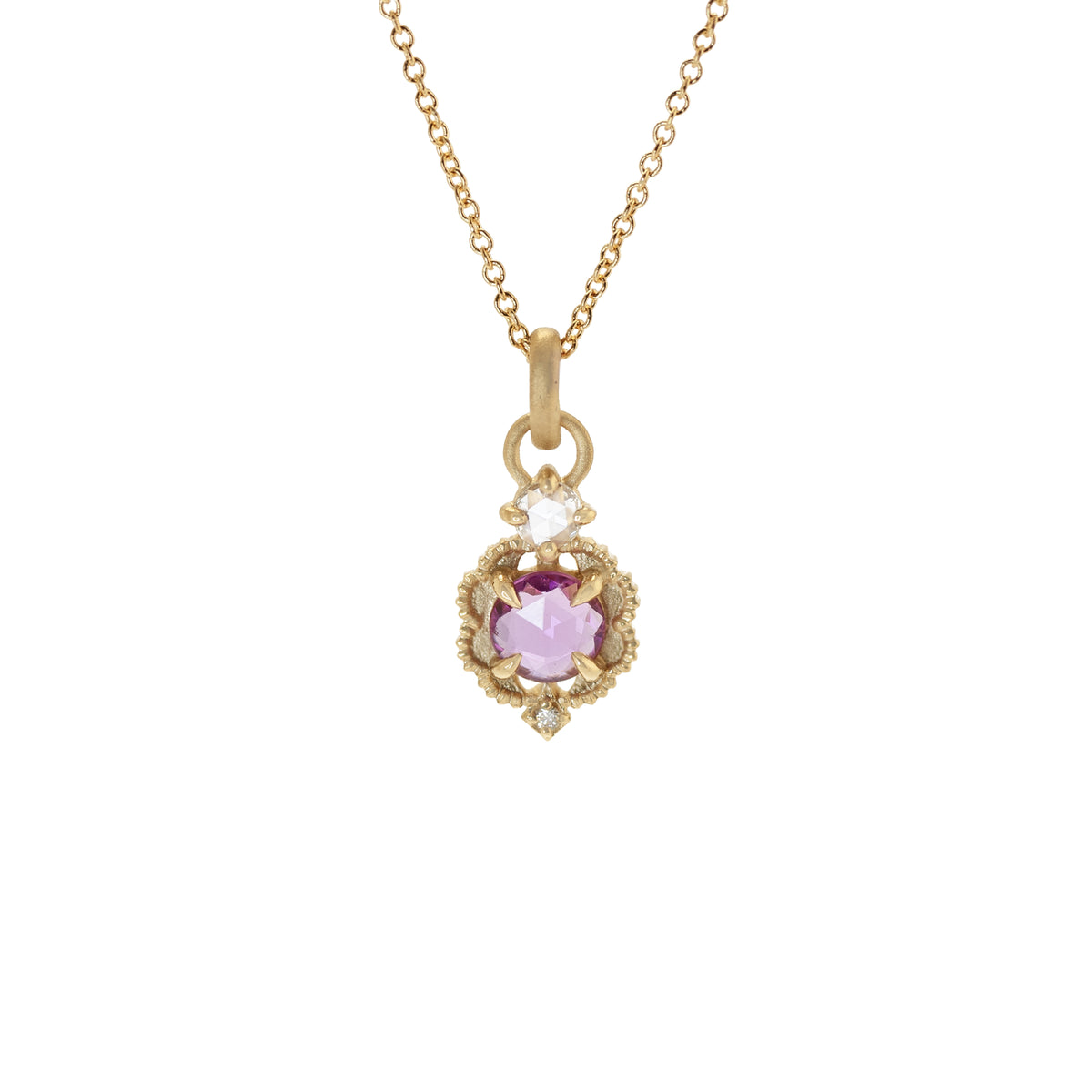 Handmade pendant necklace featuring vintage inspired venise frame setting and rose cut and round brilliant cut diamond accents and pink rose cut sapphire center stone with claw prongs and beading in 18K yellow gold by Designer Megan Thorne