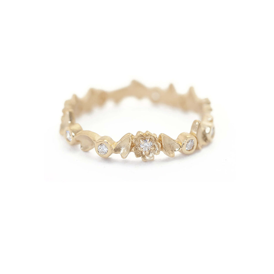 Handmade floral eternity wedding band with diamonds and flower and leaf details in 18K yellow gold by Designer Megan Thorne