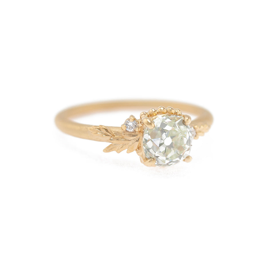 Handmade classic engagement ring featuring fancy color light green-yellow old mine cut diamond and white diamond accent with floral wood nymph details in 18K yellow gold by Designer Megan Thorne
