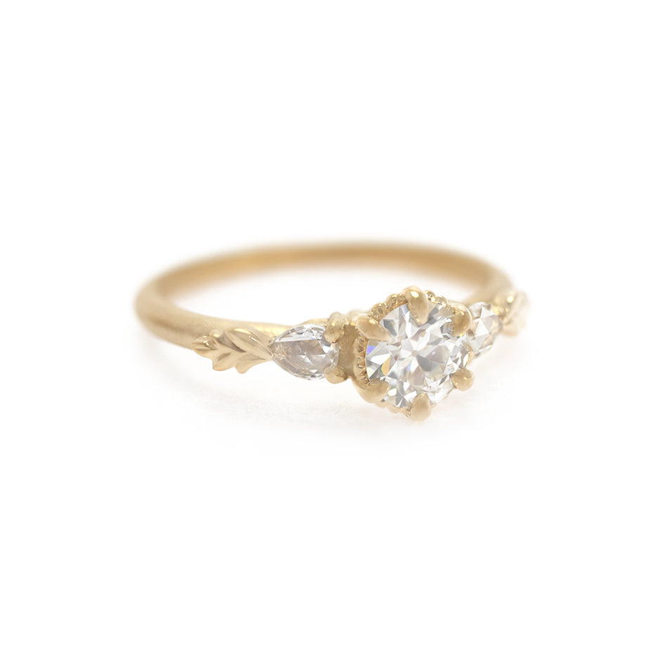 Handmade classic 3-stone engagement ring featuring .52ct old European cut diamond with pear rose cut diamond sides and floral Wood Nymph details in 18K yellow gold by Designer Megan Thorne