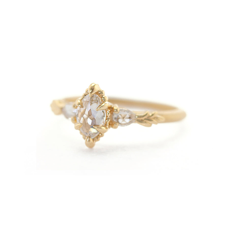 Handmade classic 3-stone engagement ring featuring non-traditional maruqise rose cut diamond center and pear side stones with floral wood nymph details in 18K yellow gold by Designer Megan Thorne