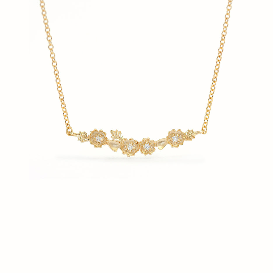 Handmade everyday bar necklace with floral Buttercup stations and botanical leaves in 18K yellow gold by Designer Megan Thorne