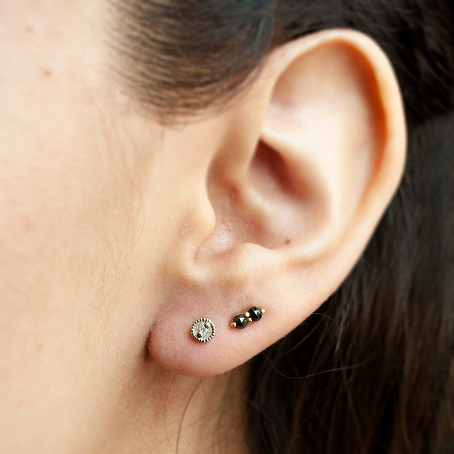 Handmade round studs with diamonds and hand carved ribbing in 18K white gold