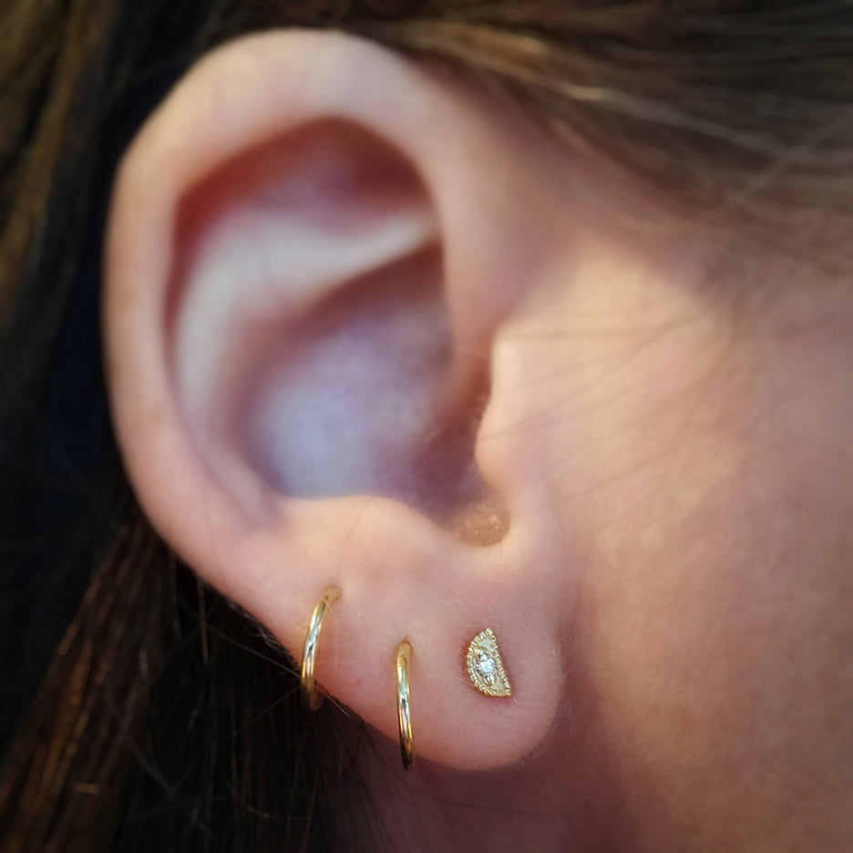 Handmade crescent shaped stud earrings with ribbing, beading and diamonds in 18K yellow gold by Designer Megan Thorne