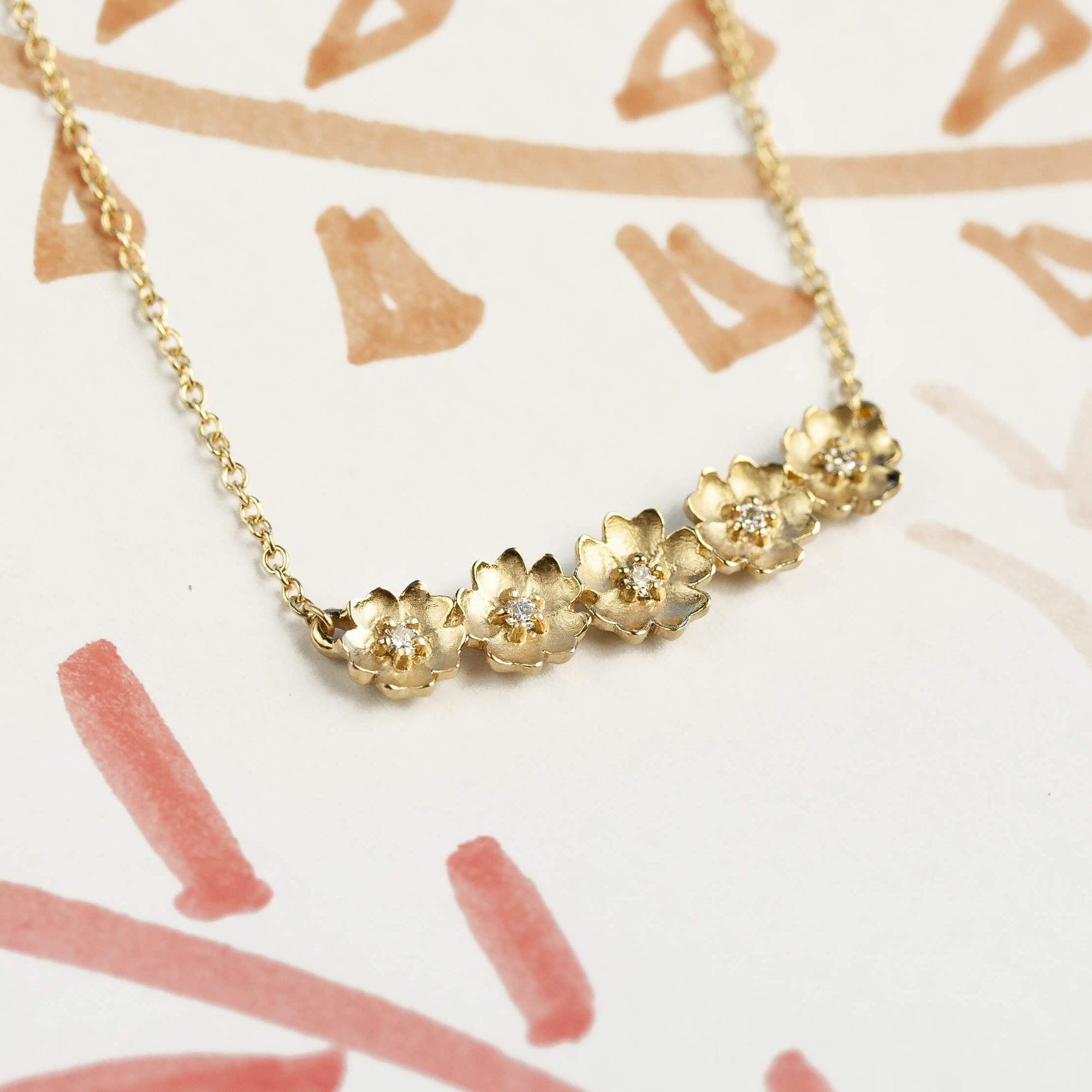 Handmade floral necklace with five Buttercup flowers with diamonds in 18K yellow gold by Designer Megan Thorne