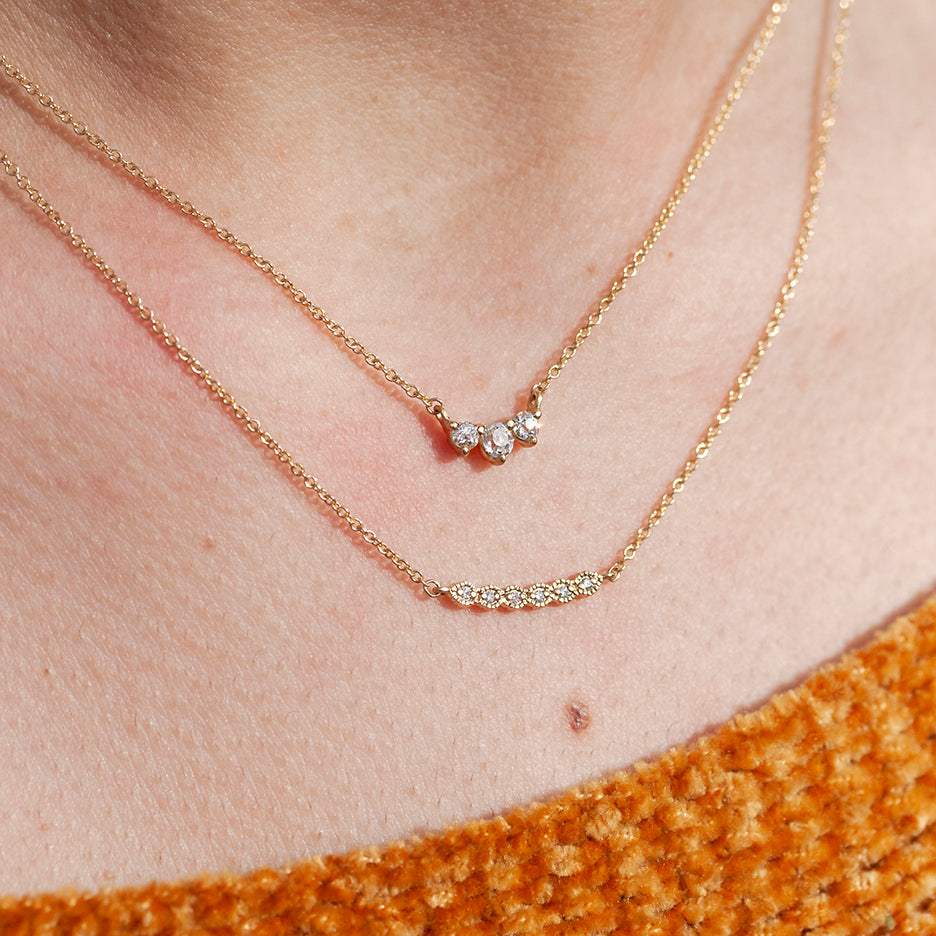 Handmade diamond necklace with vintage inspired ribbing in 18K yellow gold by Designer Megan Thorne with other fine jewelry on model