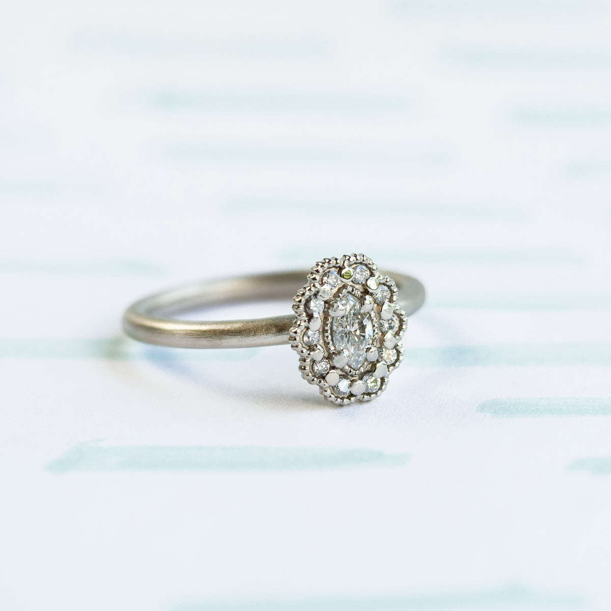 Marquise Diamond Ring in White Gold with Detailing on Colored Background