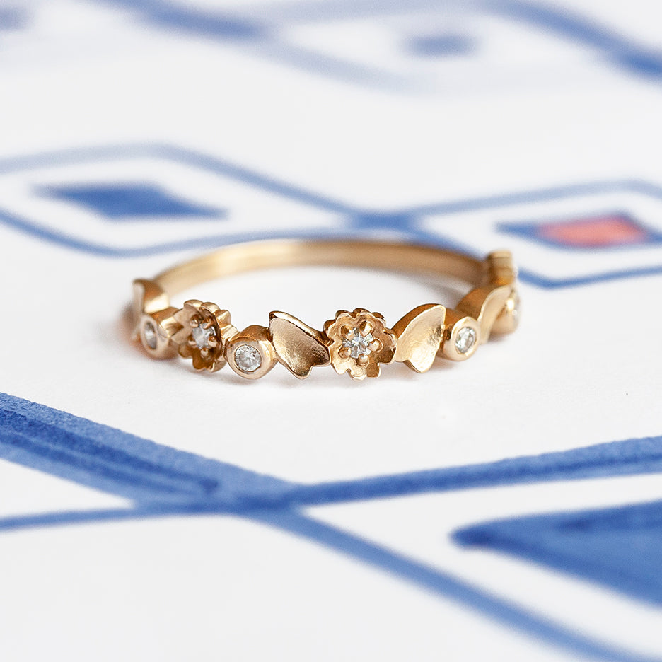 Handmade half eternity wedding band with buttercup floral details and diamonds set in 18K yellow gold by Designer Megan Thorne