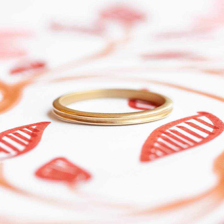 Handmade plain thin wedding band or stacking band with ione detail in 18K yellow gold by Designer Megan Thorne