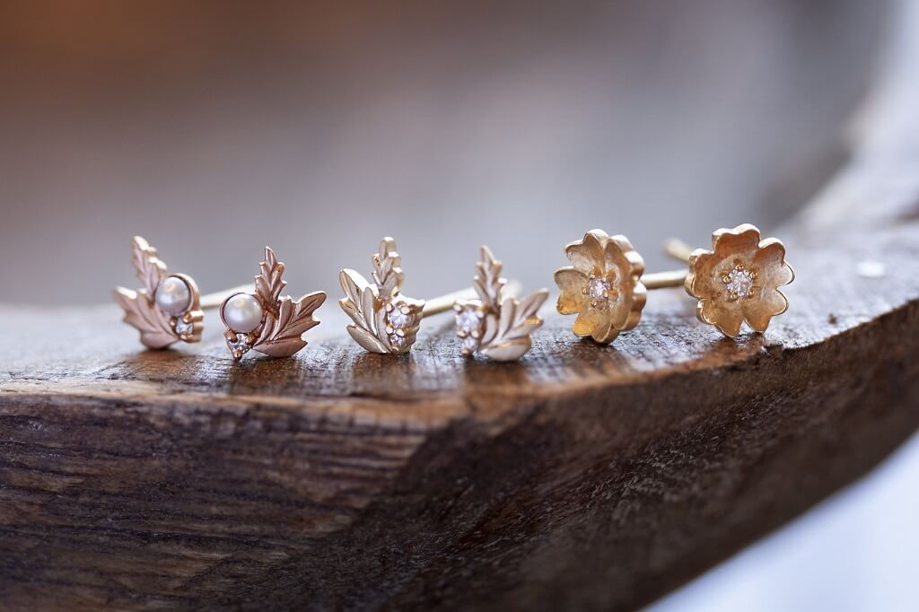 Handmade everyday stud earrings with diamonds and floral Wood Nymph details in 18K yellow gold by Designer Megan Thorne pictured with various earrings