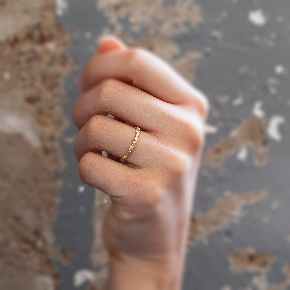 Handmade thin eternity wedding band or stacking ring featuring diamonds and hand carved floral Wood Nymph details in 18K yellow gold by Designer Megan Thorne