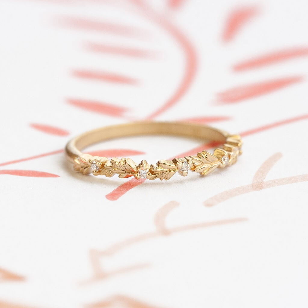 Handmade thin wedding band or stacking ring featuring diamonds and hand carved floral Wood Nymph details in 18K yellow gold by Designer Megan Thorne